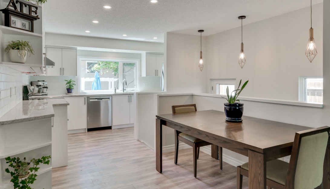 newly renovated kitchen with white cabinets and wood-look lvp flooring