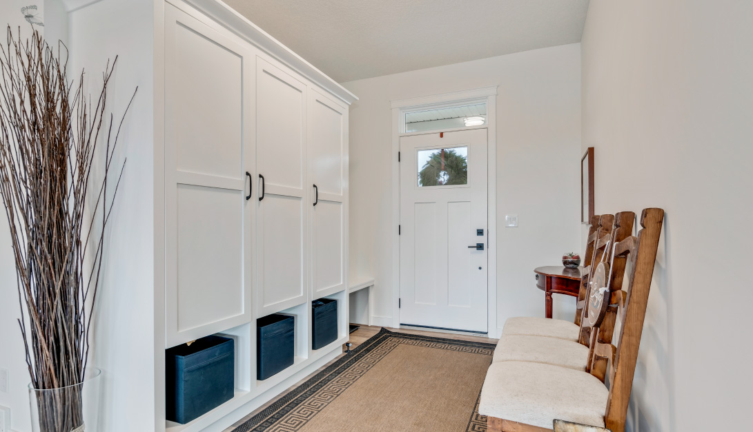 bright and welcoming entry-way mud room with a large closet and seating