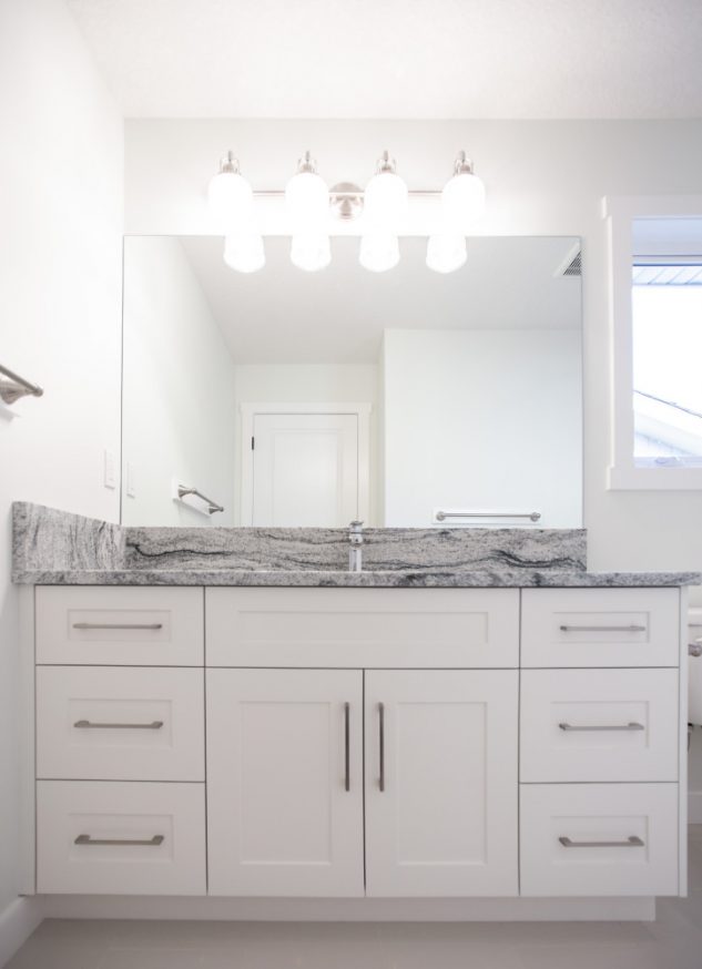 Newly renovated guest bathroom with white cabinets and bright lighting