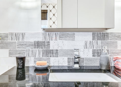 The patterned backsplash in the guest bathroom ads character to this basement renovation