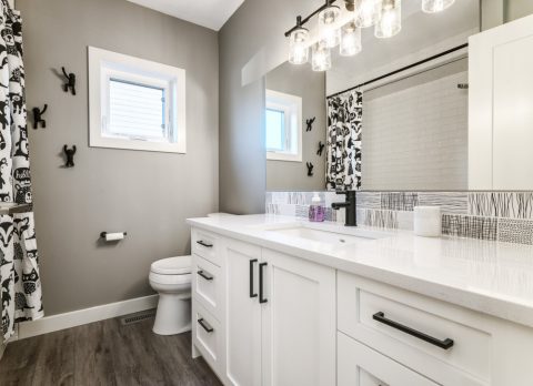Bathroom renovation with modern white cabinets and countertops