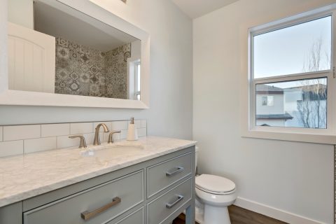 This large bathroom was custom built with gorgeous grey cabinets