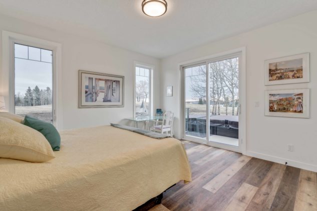 The master bedroom in this custom built bungalow has sliding doors onto a private deck