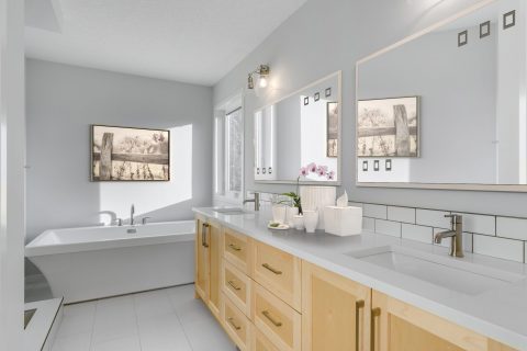 Ensuite with oak cabinets and white quartz countertops; Freestanding tub; His and her sinks