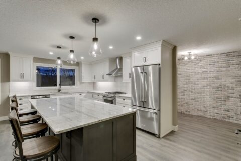 Open-concept kitchen with large island and brick wall