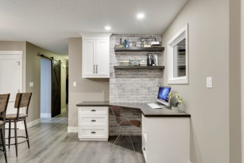 Custom desk with floating shelves and brick wall