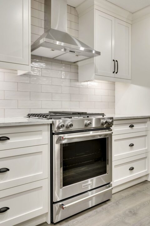 Open-concept kitchen with large kitchen island. White cabinets with maple stained island.
