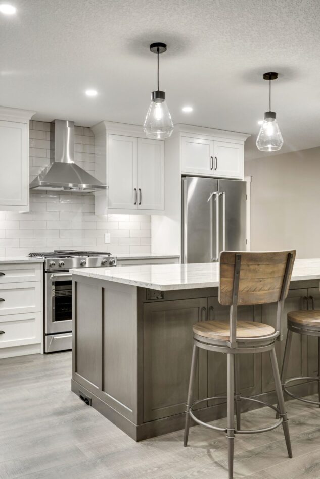Open-concept kitchen with large kitchen island. White cabinets with maple stained island.