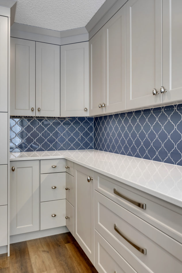 Blue tiled backsplash with corners drawers in grey custom cabinetry 