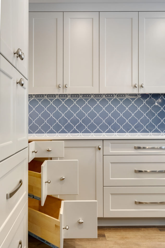 Blue tiled backsplash with corners drawers in grey custom cabinetry 