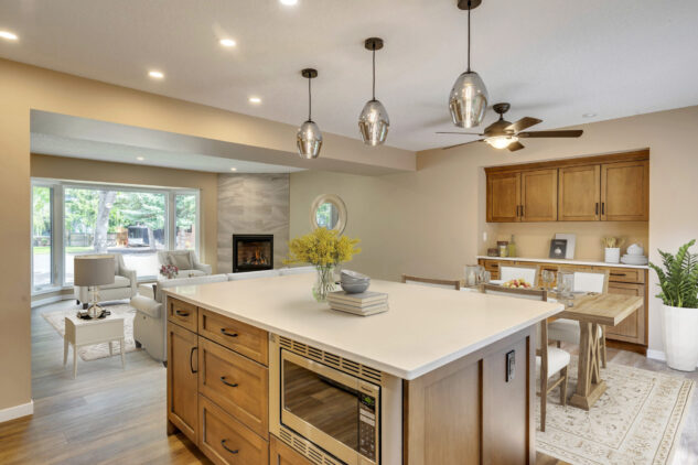 Stained kitchen island with white perimeter cabinetry. Stained custom dining hutch with farmhouse style dining table. Open to living room.