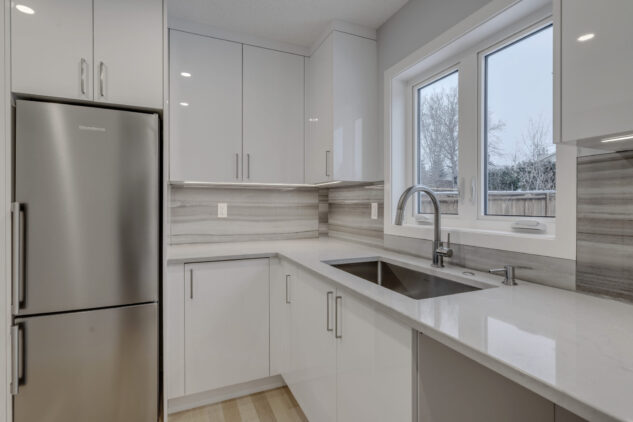 Kitchen scullery with high gloss cabinets and grey countertops