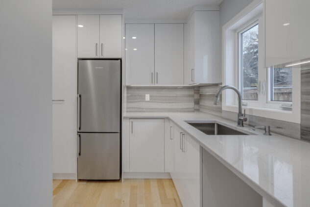 Kitchen scullery with high gloss cabinets and grey countertops