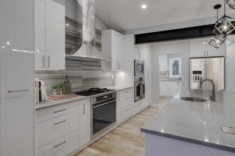 Modern high gloss kitchen cabinetry with grey quartz countertops