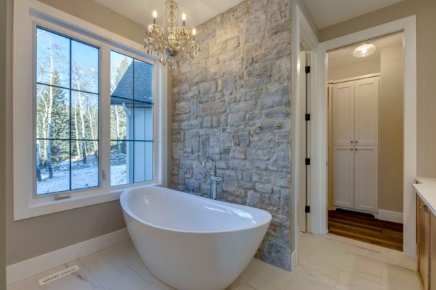 Ensuite free-standing tub with custom stone wall