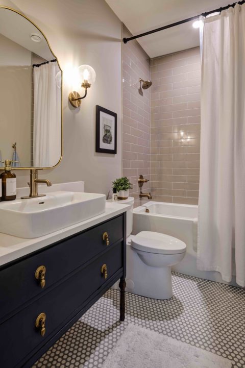 Main bathroom with custom furniture vanity and tiled tub