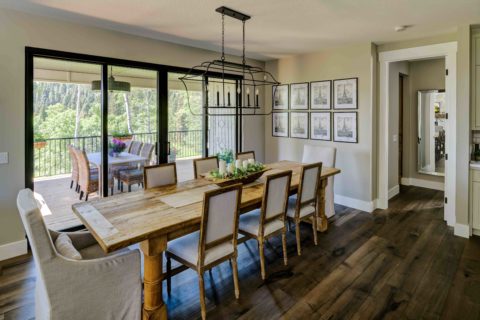 Dining room with wide plank hardwood and large wood farmhouse dining table
