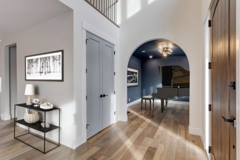 Calgary infill custom home builder. Music room with arched entry way with piano. 