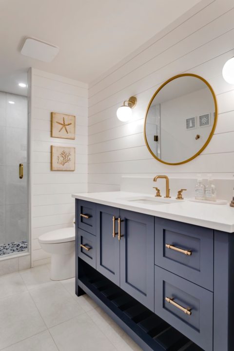 Calgary, Alberta custom home builder with custom blue vanity with floating shelf and venetian bronze hardware. Shiplap feature wall. 
