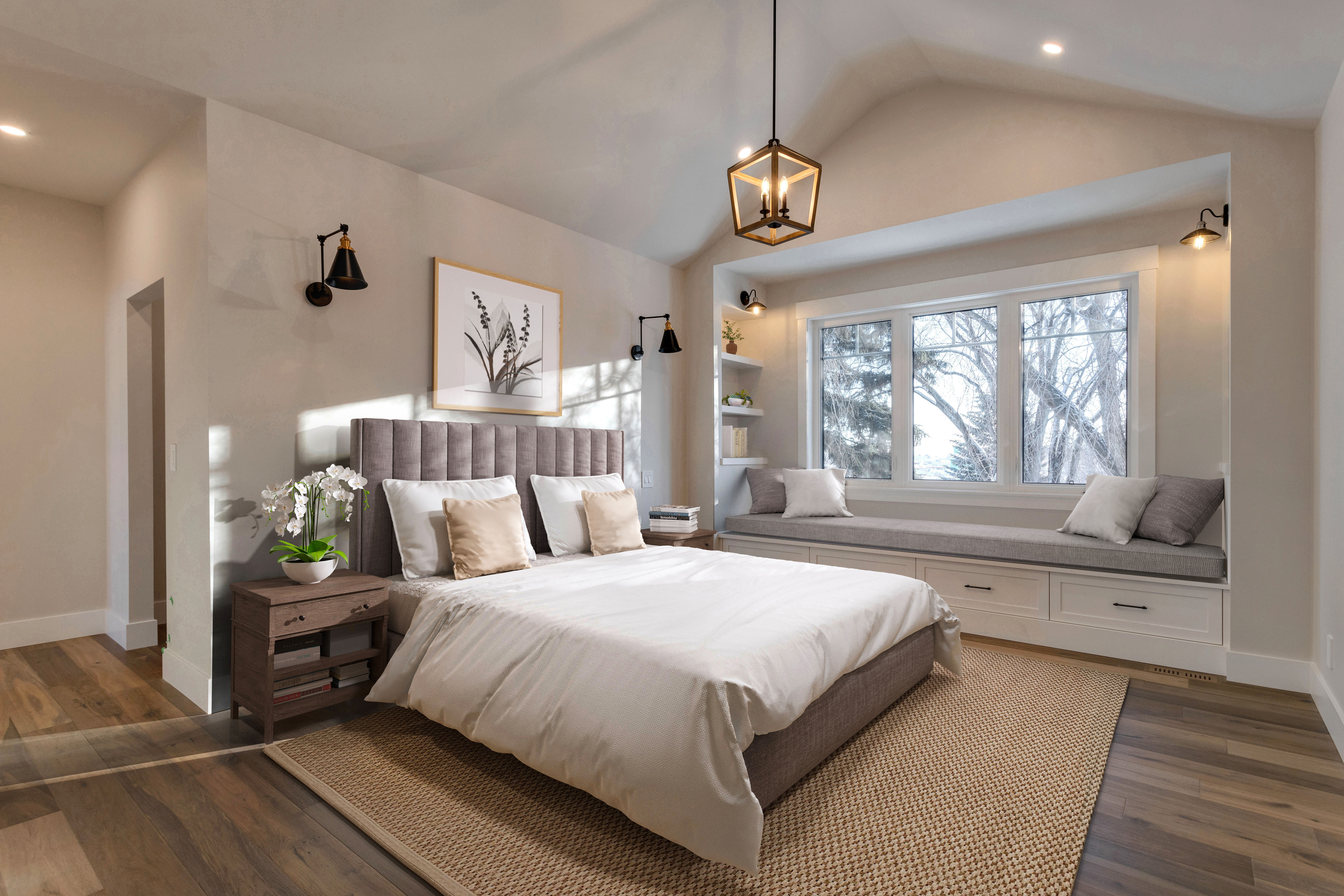 A primary bedroom with a recessed reading nook and large bed in the middle of the room.
