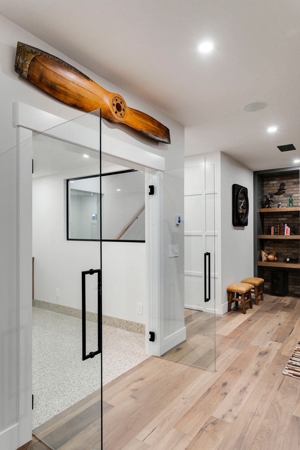 Open glass doors leading into basement brewery room in new Calgary custom home