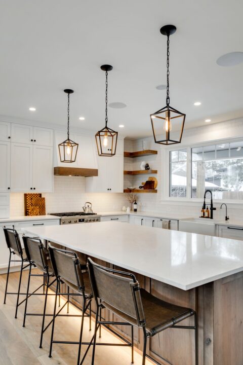 Calgary infill custom home builder. White paint-grade kitchen with knotty maple island. Floating shelves, pendant lights, full height subway tile backsplash.  Modern farmhouse.