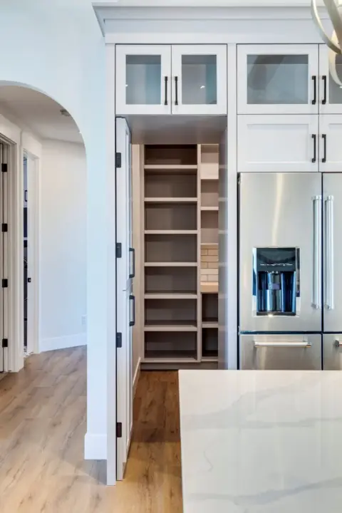 View into hidden butler's pantry in kitchen of custom Dewinton home