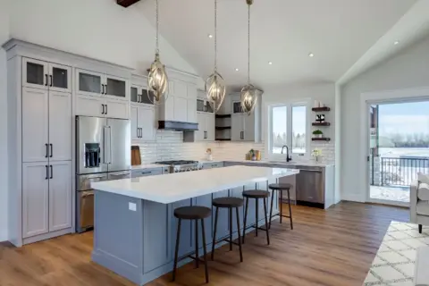 Kitchen with custom Shaker cabinetry and hood fan and large island
