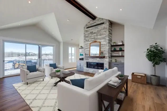 Light-filled great room with vaulted ceilings, accent beam, floor-to-ceiling stone fireplace