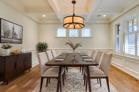 Refinished hardwood flooring anchors elegant dining room with coffered ceiling