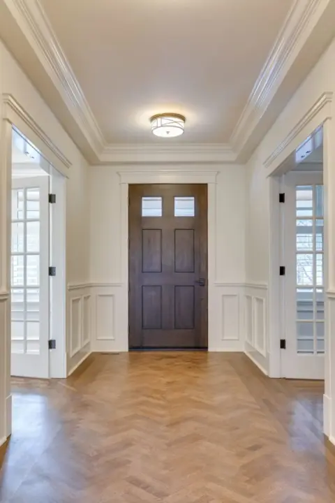 Interior of entry with refinished herringbone patterned wood floors