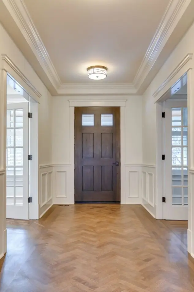 Interior of entry with refinished herringbone patterned wood floors