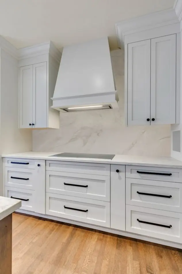 Custom white Shaker cabinetry and hood fan