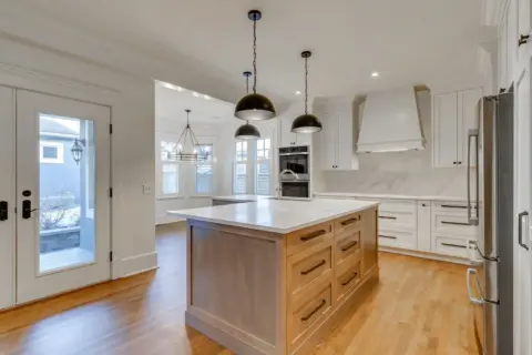 Generous L-shaped island with (type of wood/stain) cabinetry and striking black hardware