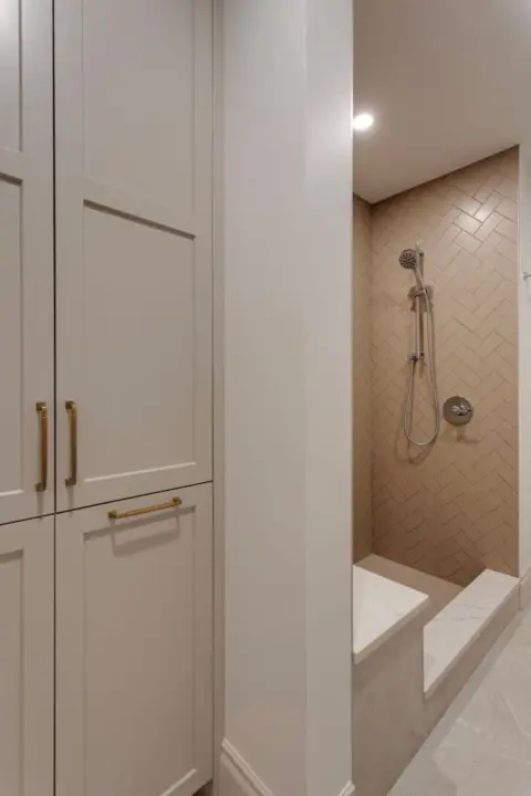 Closeup of cabinetry storage and shower in ensuite bathroom