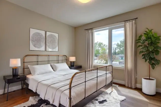 Bedroom in carriage home with a large window and painted in neutral, calming shade.