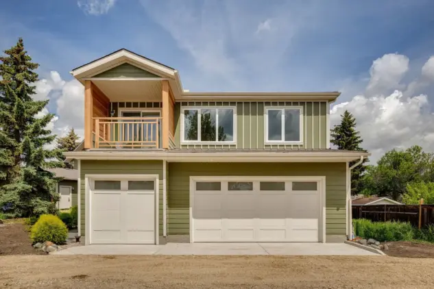 Exterior of triple car garage with carriage home above, with a covered balcony.
