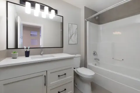 Guest bathroom in fully renovated Cranston home with custom cabinetry, white quartz countertop and updated fixtures