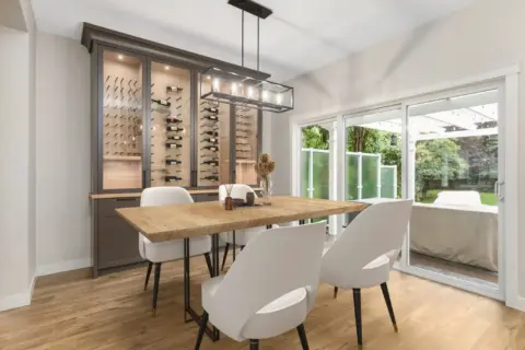 Dining room with stunning custom wine cabinet with glass doors and integrated lighting in fully renovated Cranston home