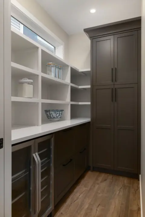 Butler's pantry with custom cabinetry, beverage fridge and wine storage in fully renovated home by Melanson Homes