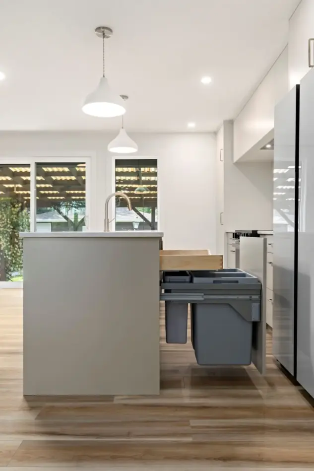 Streamlined cabinetry with hidden storage solutions and a garbage and recycling center in a Varsity home renovated by Melanson Homes
