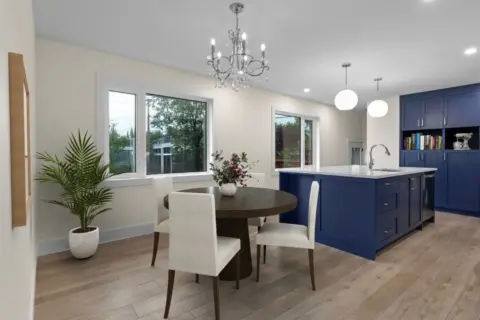 Open dining room and kitchen with bold blue custom cabinetry in renovated and expanded Charleswood home